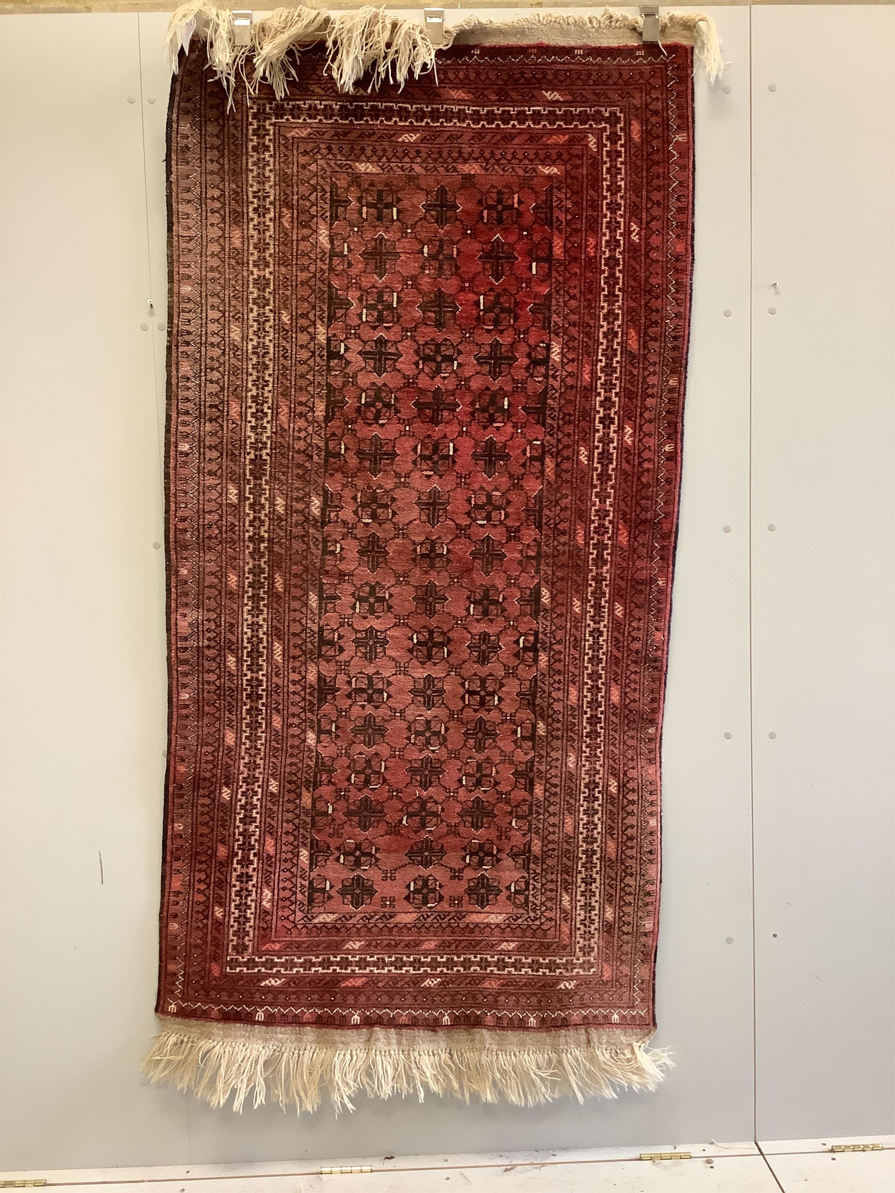 An Afghan red ground rug, 200 x 106cm. Condition - fair